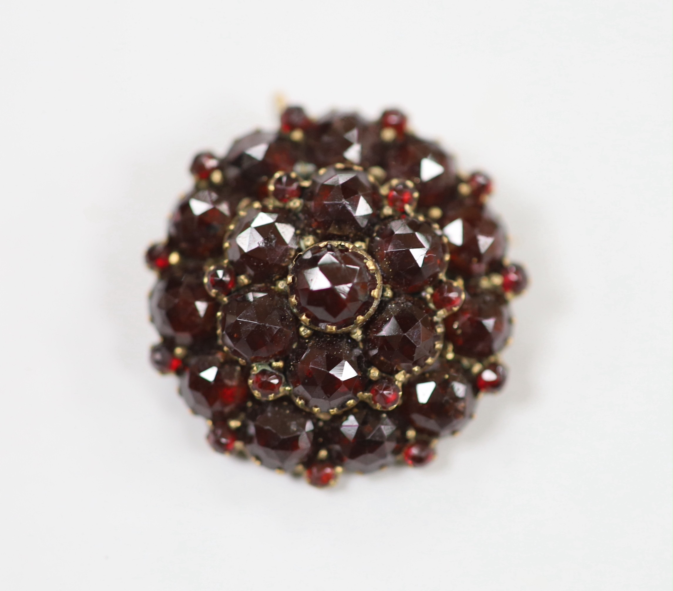 A yellow metal 'shamrock' bar brooch, 36mm, 1.6 grams and a late Victorian gilt white metal and garnet cluster set pendant brooch.